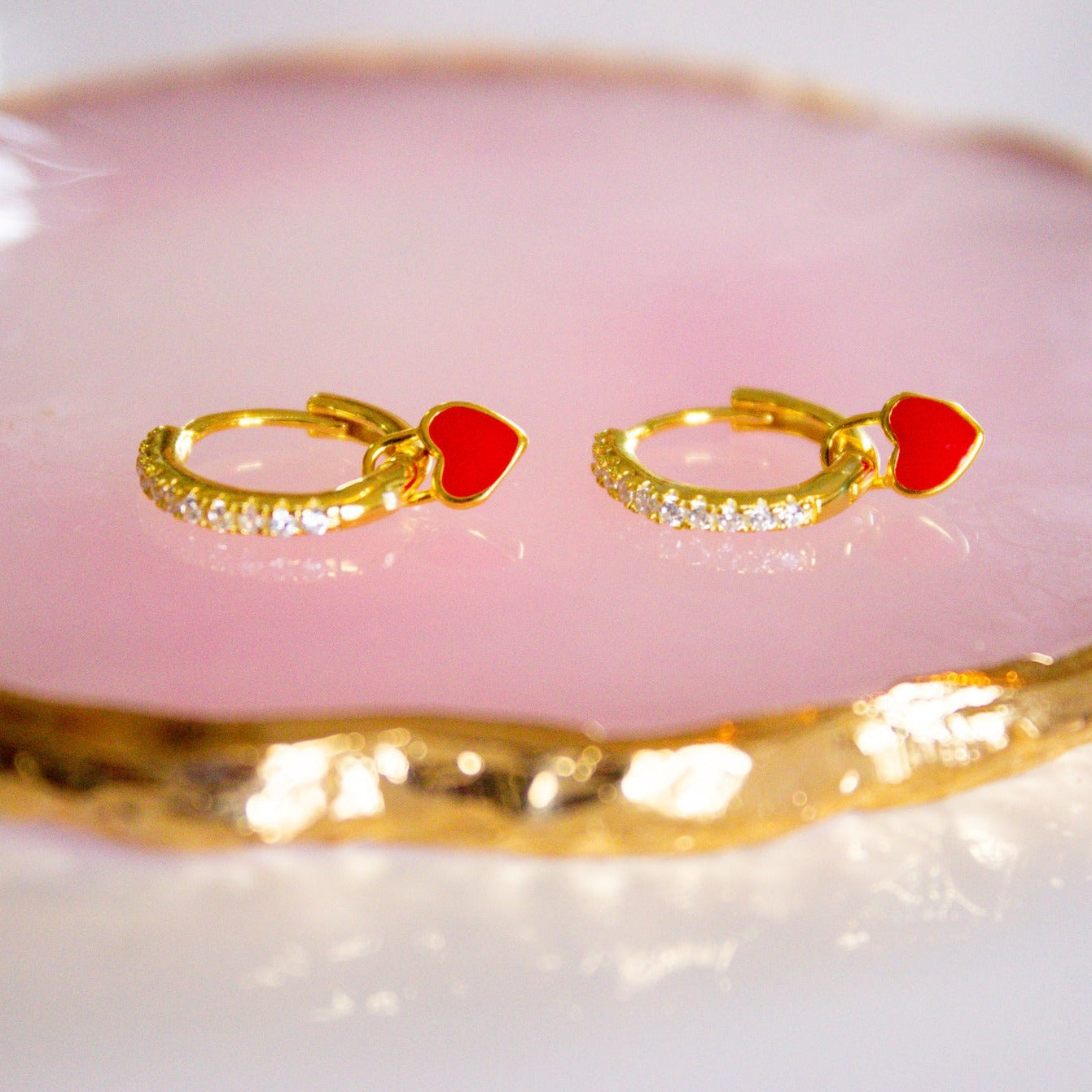 gold hoops with red heart charms