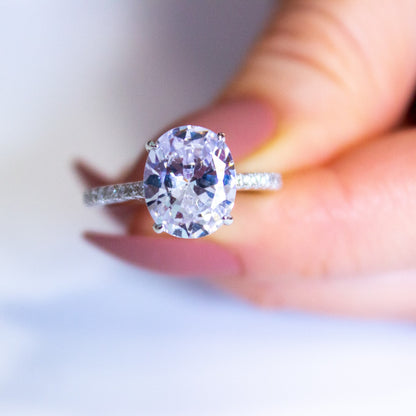portrait style photo of two fingers holding oval ring